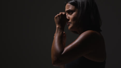 Foto-De-Estudio-De-Perfil-De-Una-Mujer-Madura-Vistiendo-Ropa-De-Gimnasio-Haciendo-Ejercicio-De-Sparring